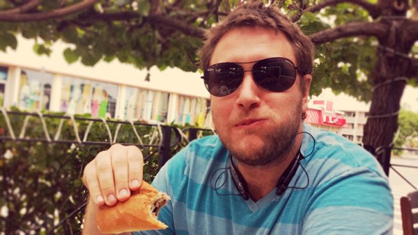 Matt in sunglasses, holding up a snack